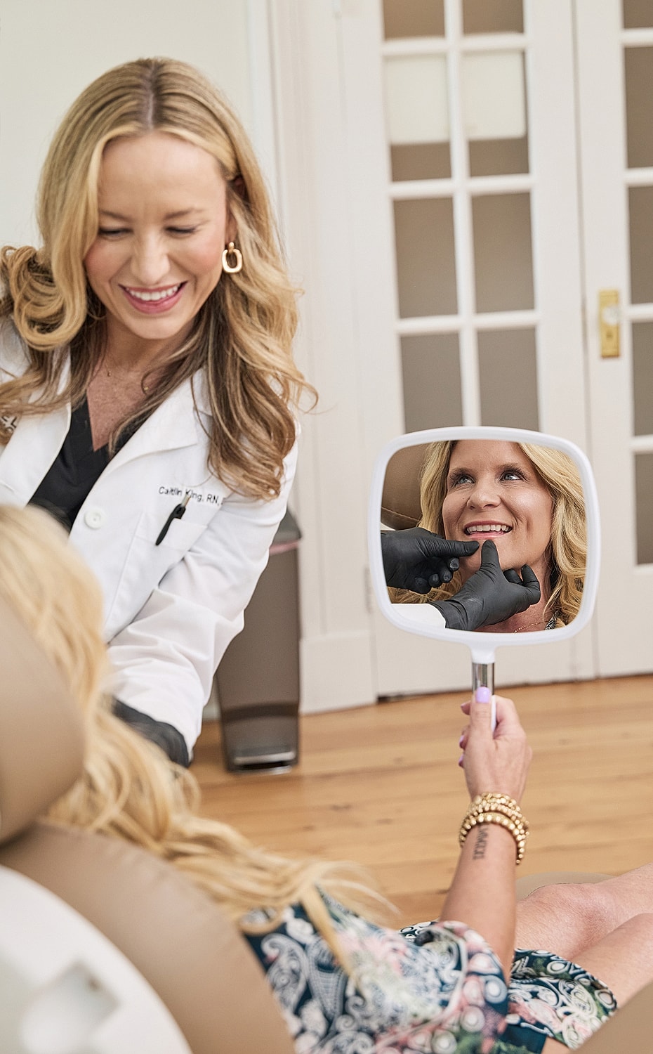 Dental consultation with patient smiling in mirror.