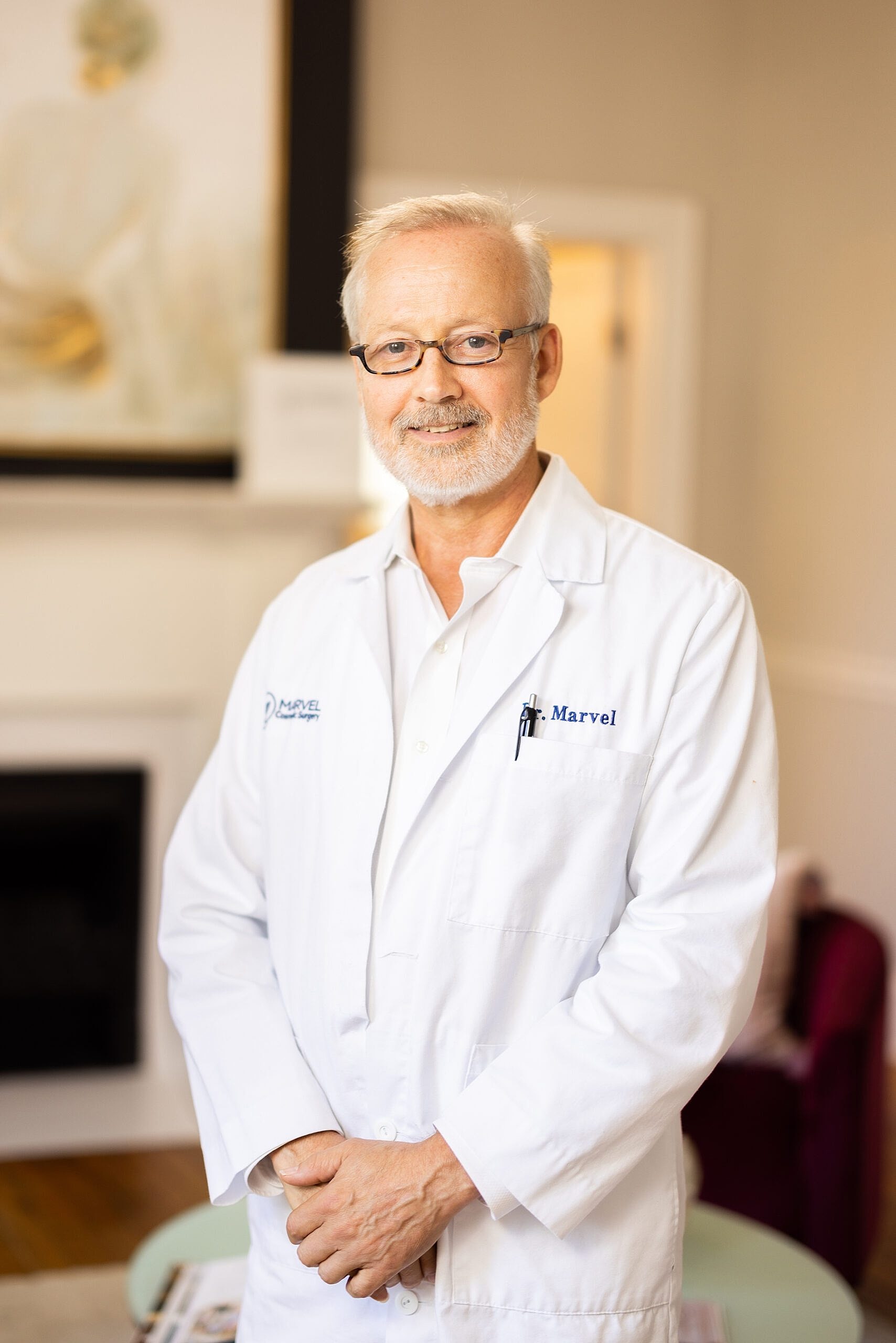 Doctor in white coat smiling in office setting.
